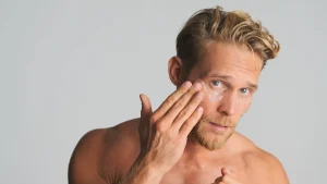 1 handsome-blond-bearded-man-applying-eye-patches-take-care-his-skin