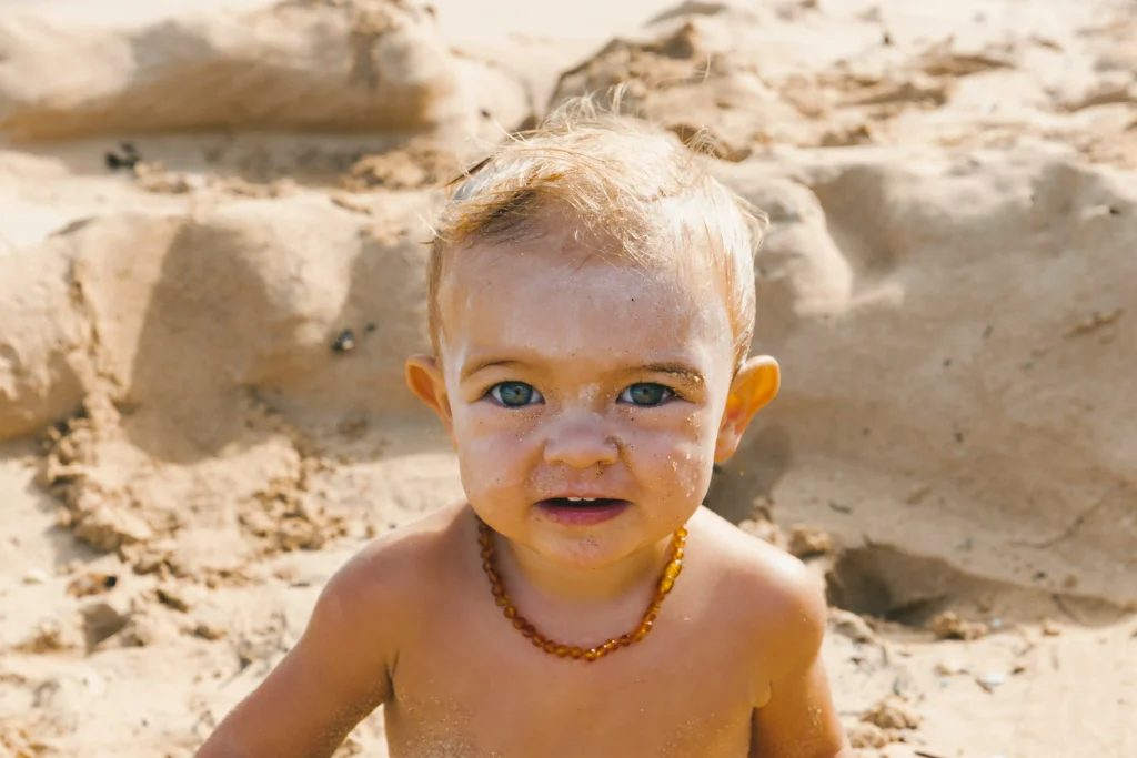 a little boy standing at the sand