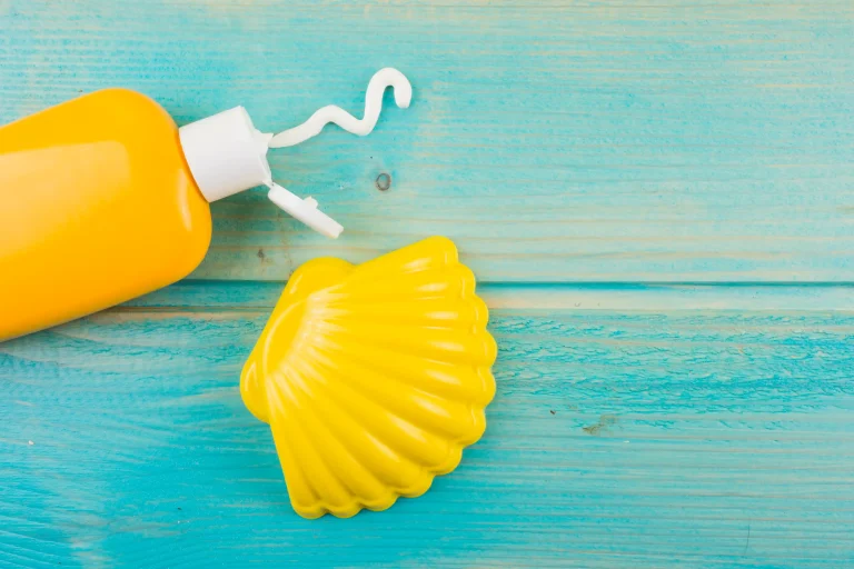 sunscreen-lotion-bottle-plastic-yellow-scallop-turquoise-wooden-desk