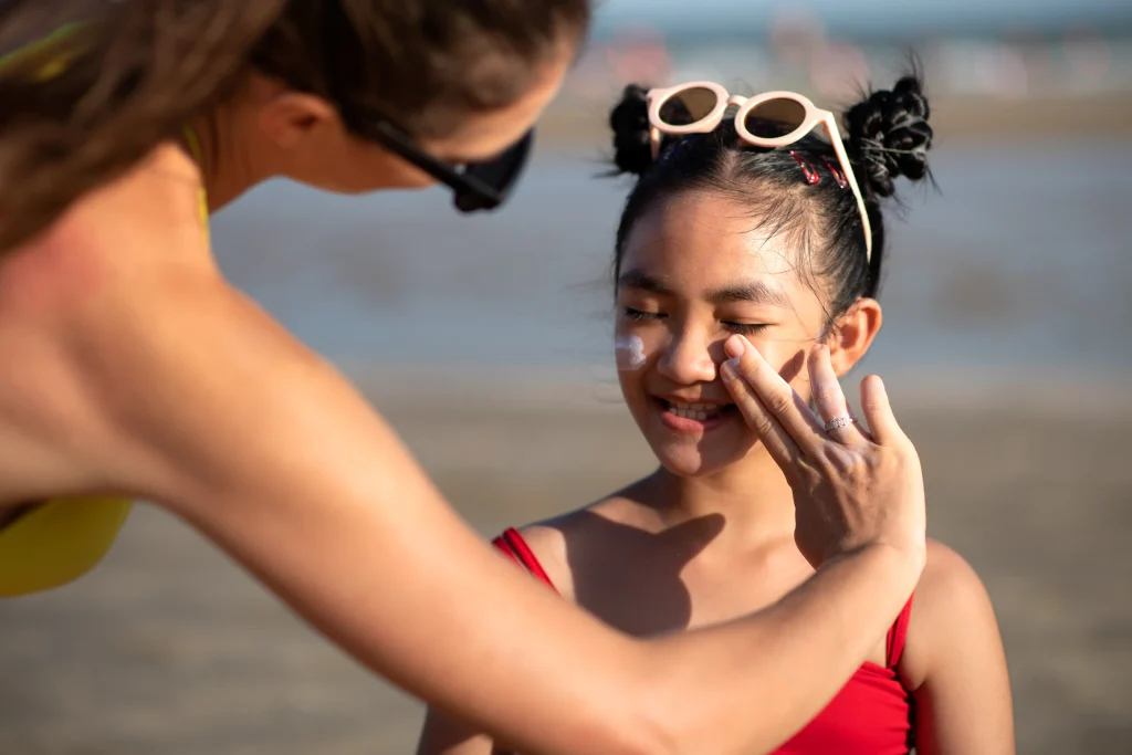 woman-applying-sunscreen-kid-front-view