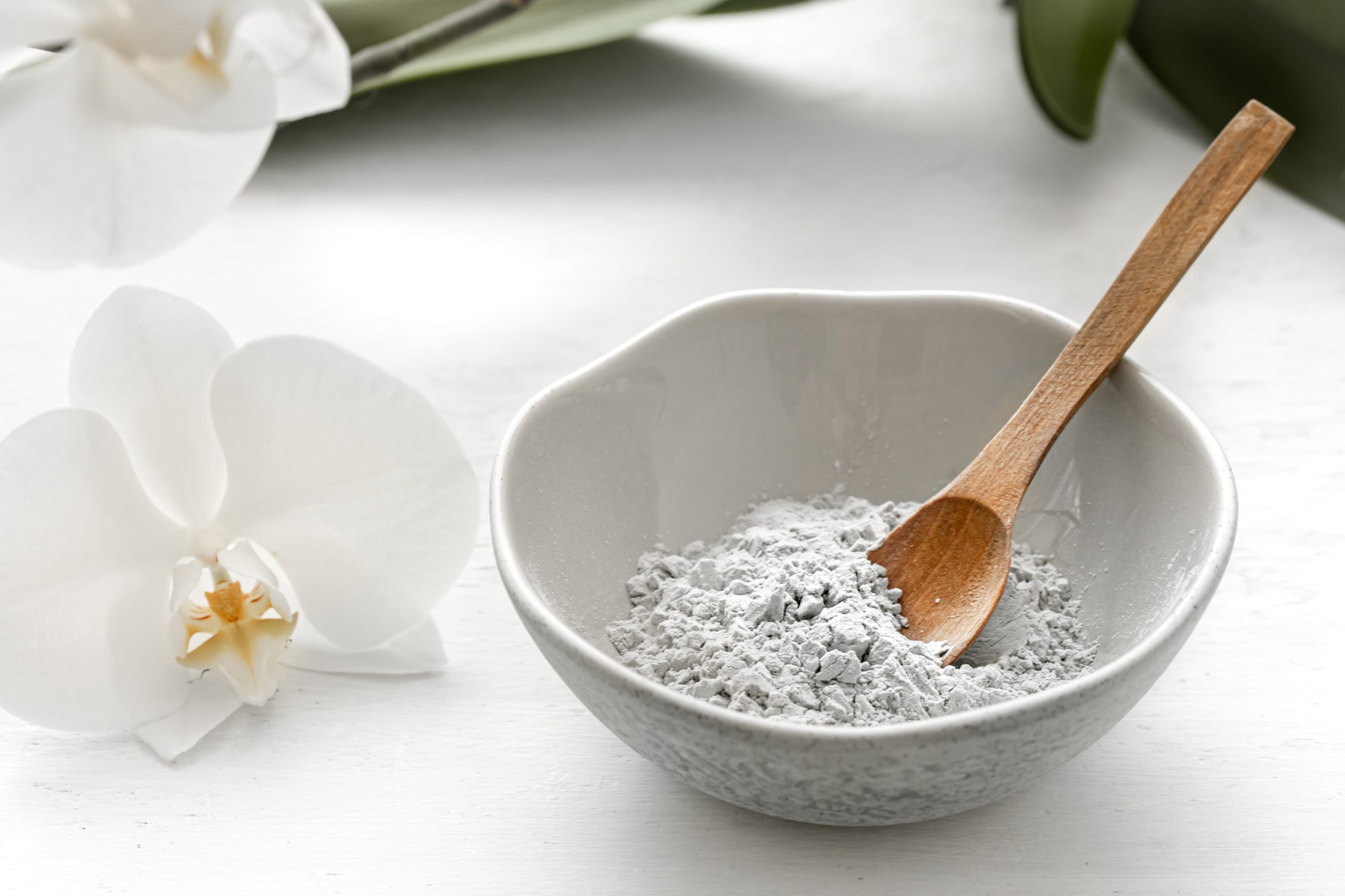 Spa composition with powder face mask and orchid flower.